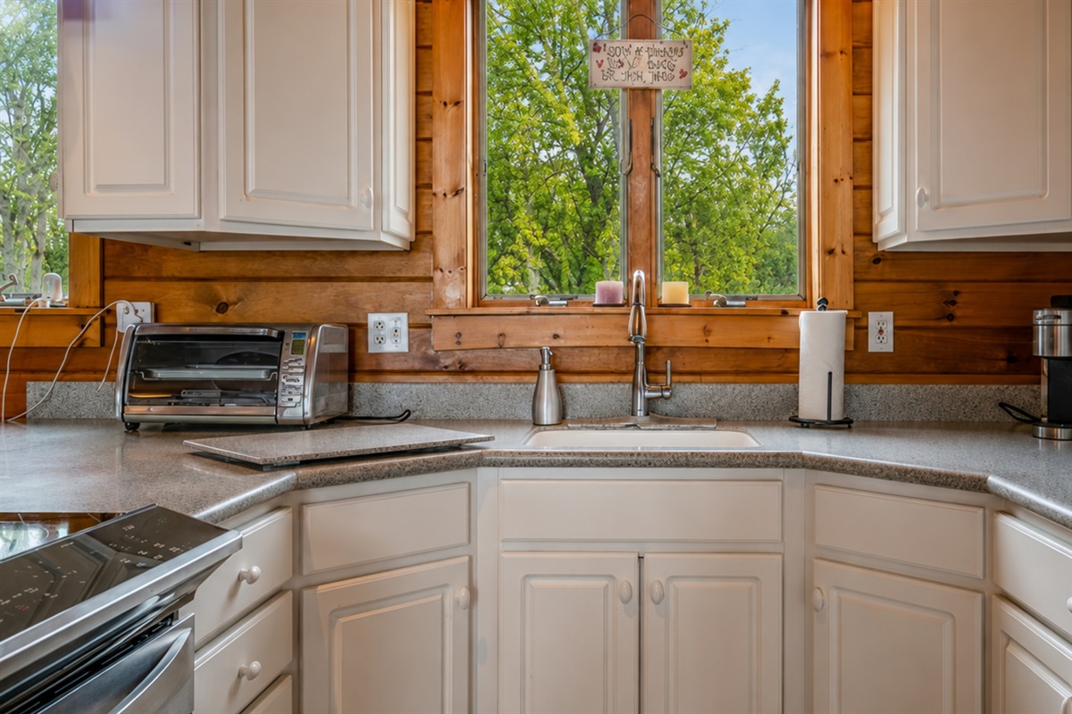 Cozy kitchen with modern appliances and scenic views, perfect for cooking and relaxing.