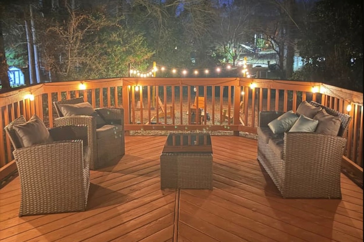 Enjoy peaceful evenings on your private deck with cozy seating, soft string lights, and a wooded view — perfect for relaxing after a day exploring Raleigh.