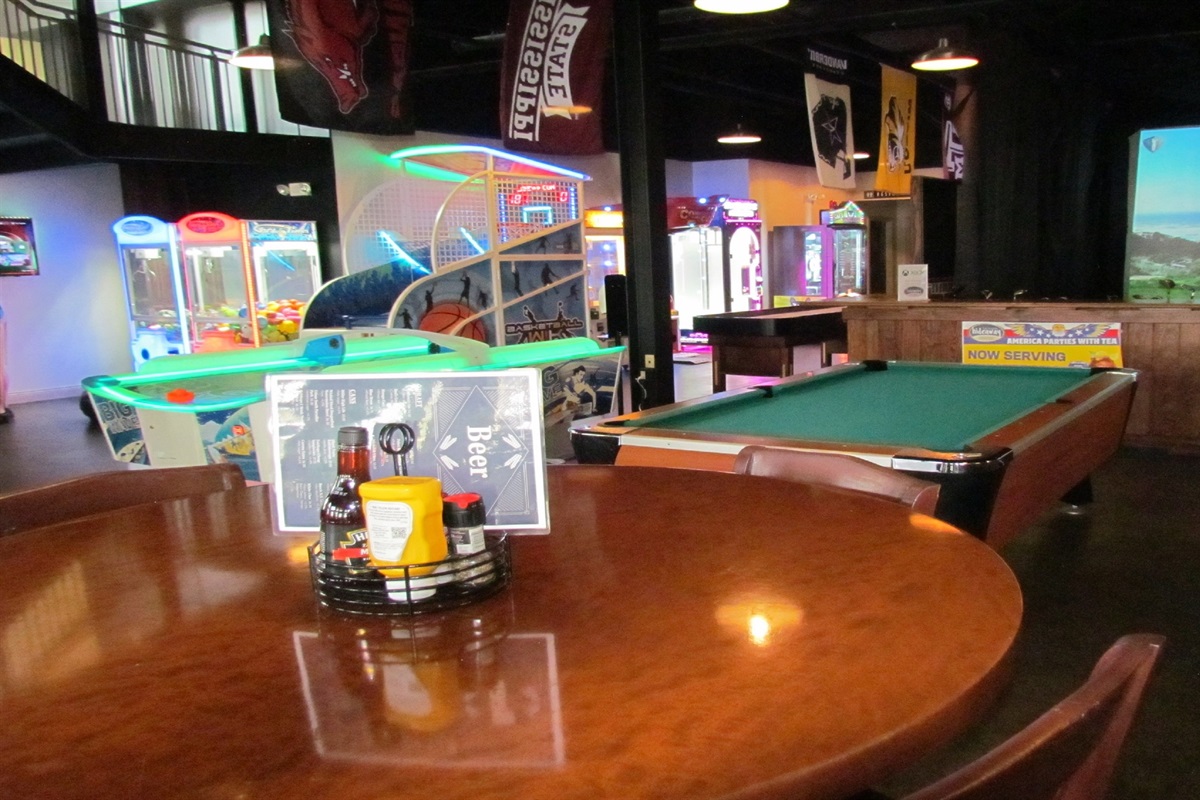 Unleash your inner gamer at the Village Hideaway's vibrant arcade, featuring a wide array of classic and modern games including basketball, shuffleboard, and more, for endless family fun.