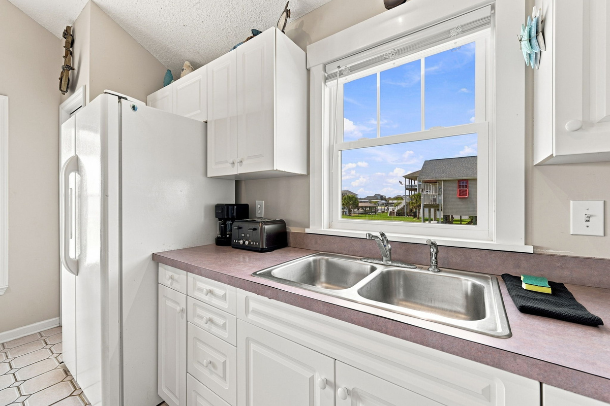Prep meals with natural light streaming through the kitchen window and enjoy a bright, inviting workspace