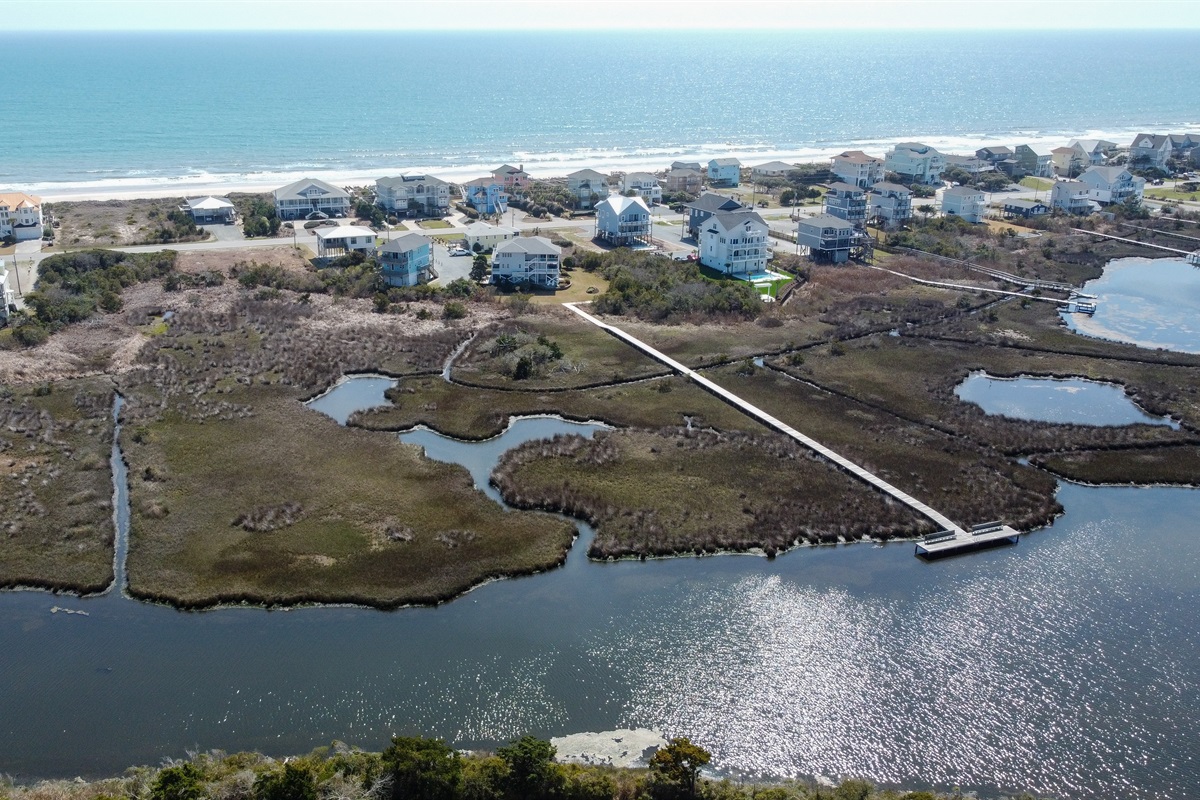 Aerial view of the marsh, sound, and private dock behind the home