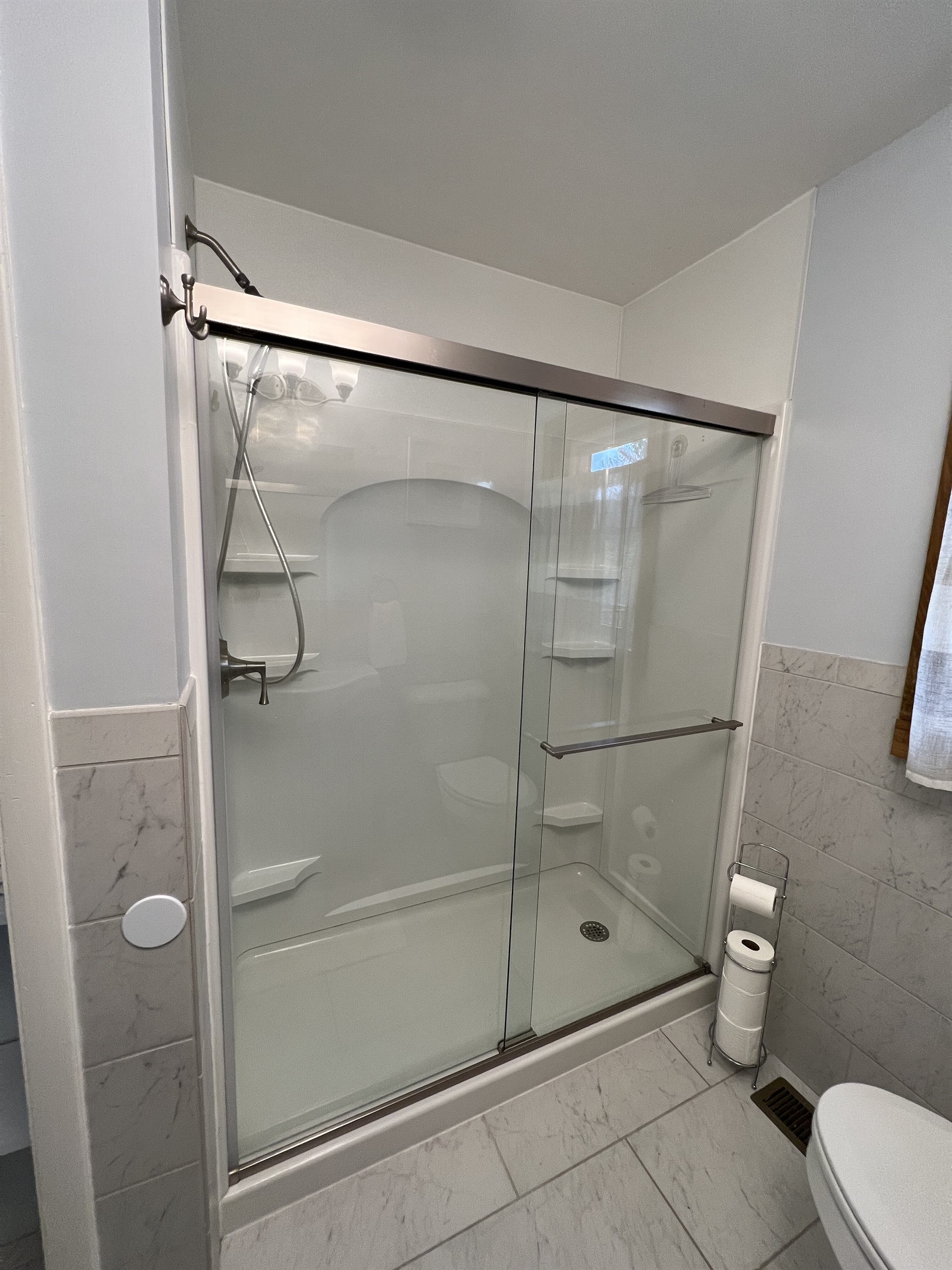 Wide shower with glass doors.