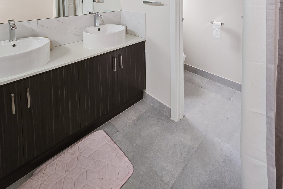 Marble-look tiling, twin basins and a spacious walk-in shower give this bathroom a polished, premium feel within Willows Stays Holiday.