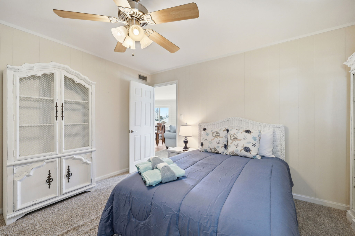 Cozy bedroom featuring a comfortable double bed and coastal-inspired d&eacute;cor
