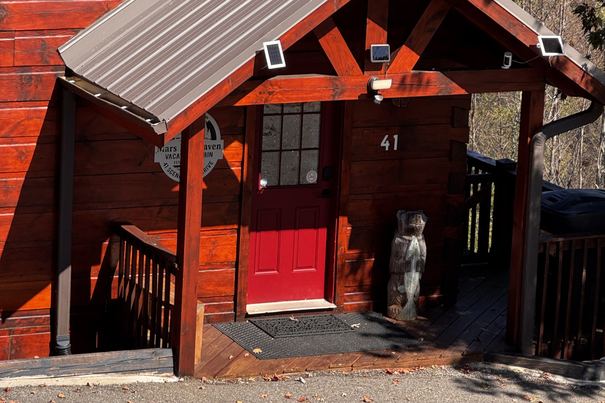 A closer look at the log cabin exterior and covered front entrance.