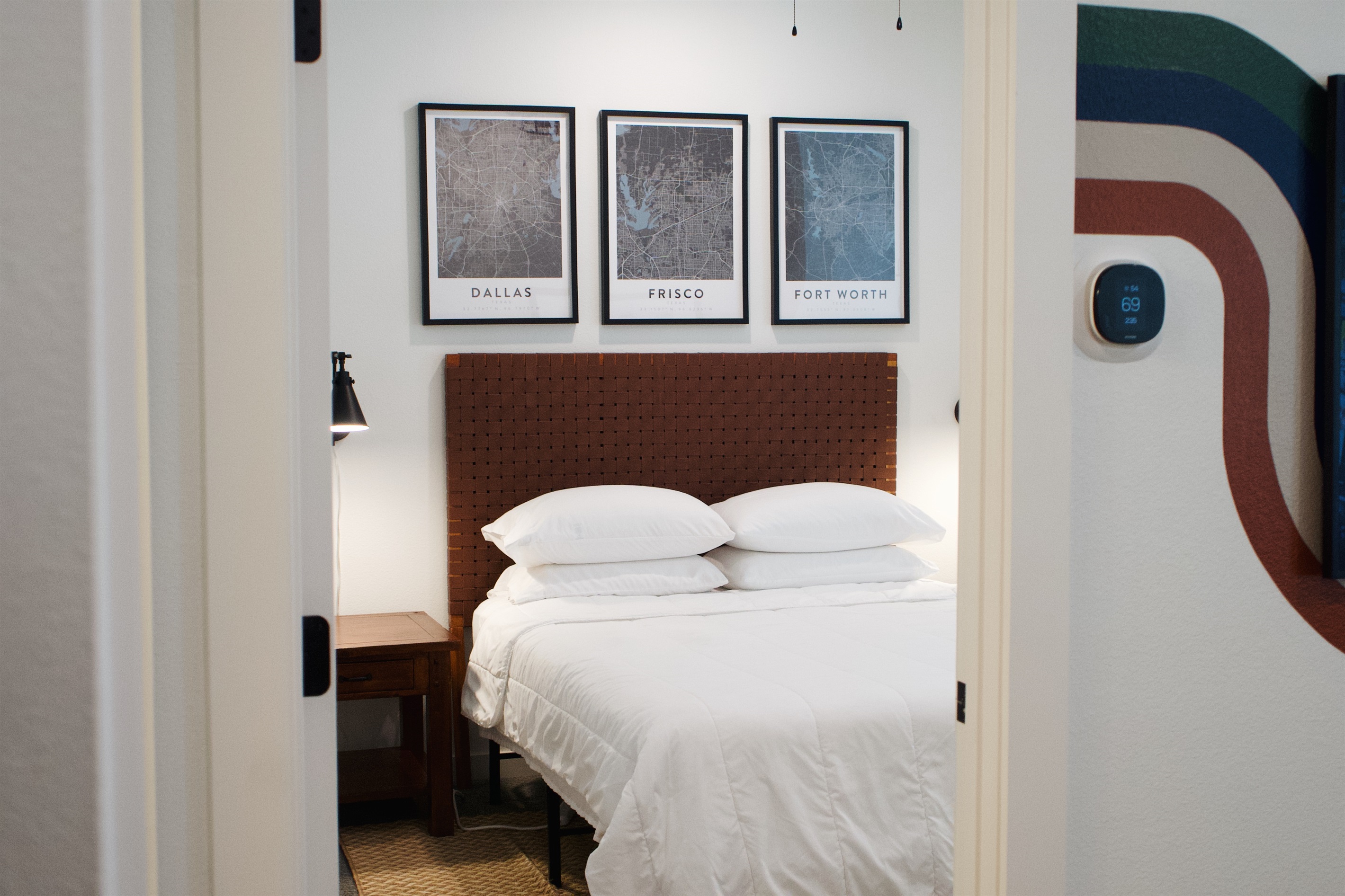 Comfortable bedroom with quality linens and framed local maps, creating a calm and restful space.