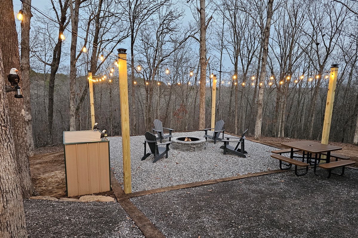 Spend golden-hour evenings by the fire pit under café lights, with Adirondack seating and a nearby picnic table—perfect for relaxed family moments or quiet, romantic nights wrapped in nature a