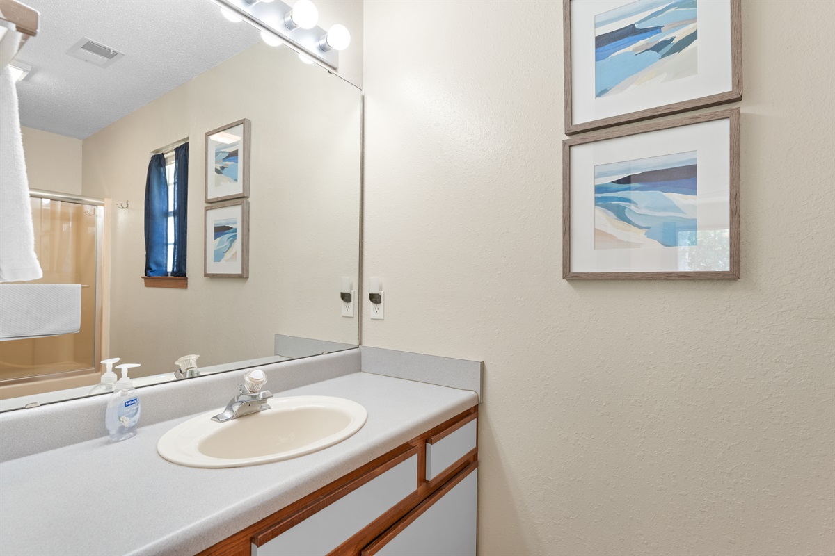 Primary full bathroom with large mirror and ample counter space.