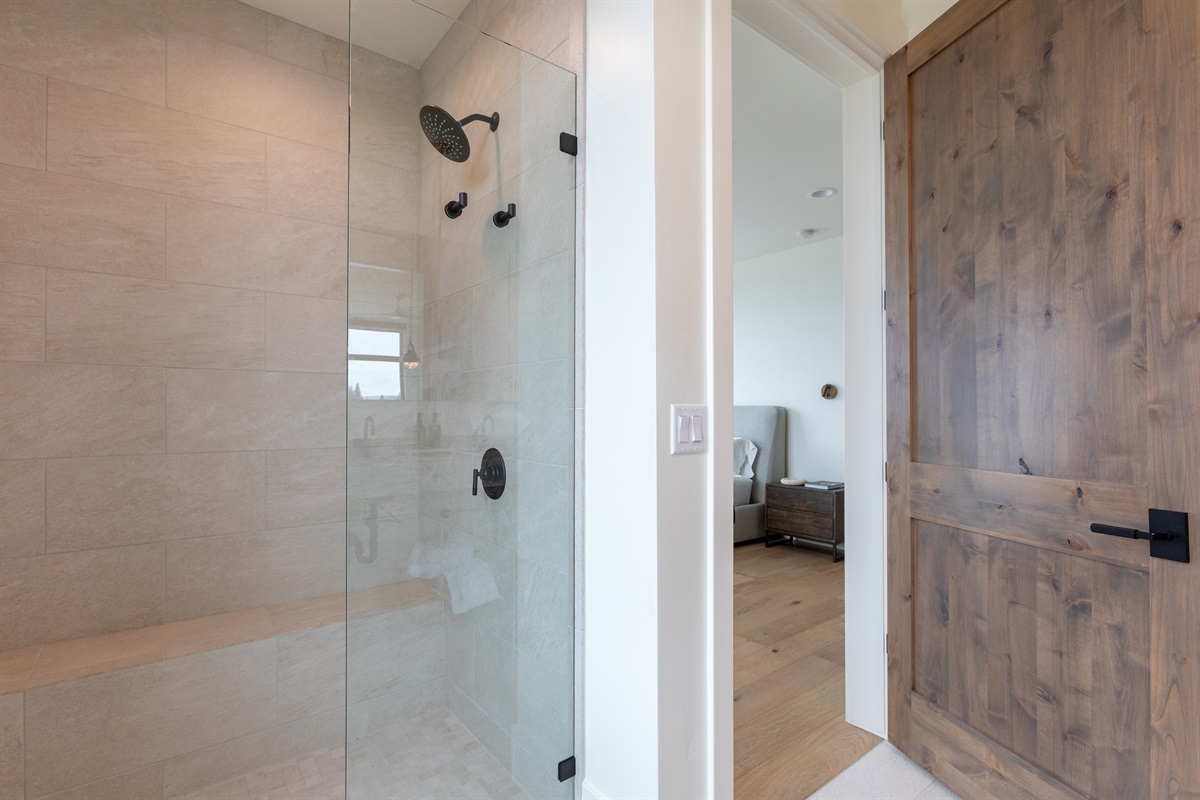 Middle Teton - Sleek walk-in shower with glass enclosure and warm natural tile.