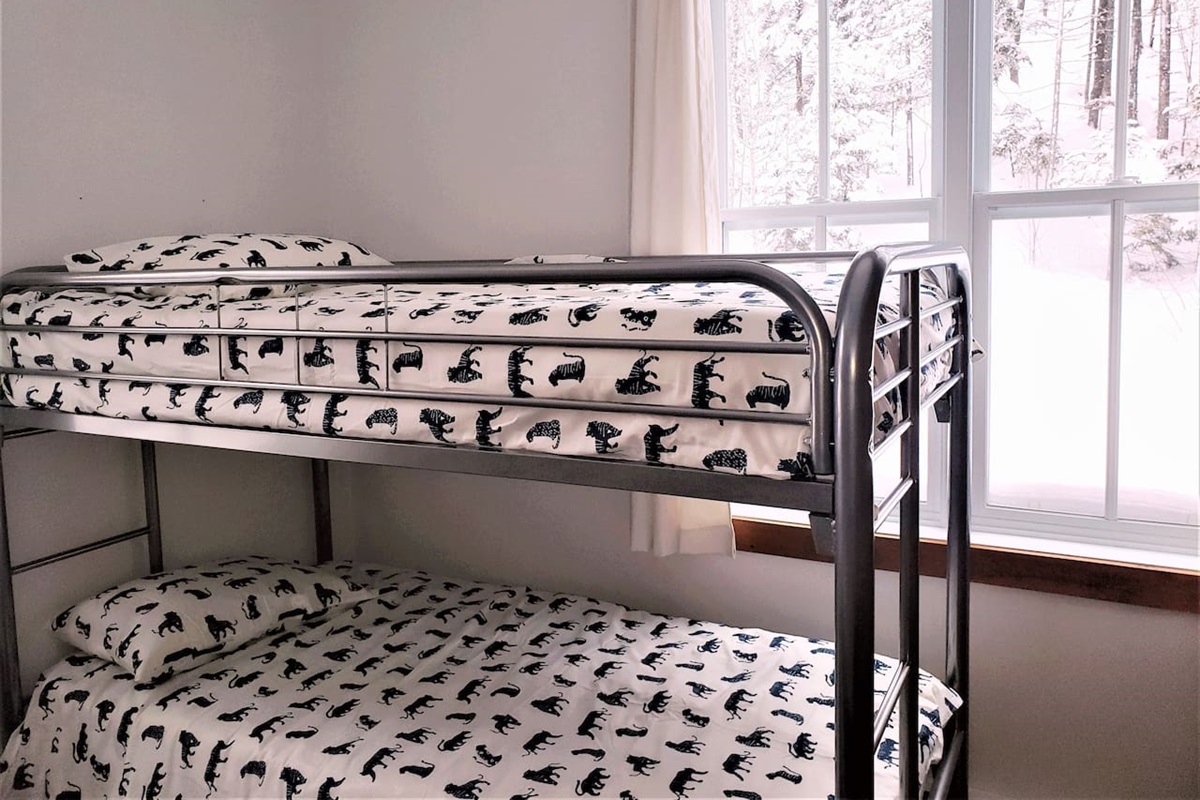 Chambre #2 au rez-de-chaussée avec un lit queen et un lit superposé.