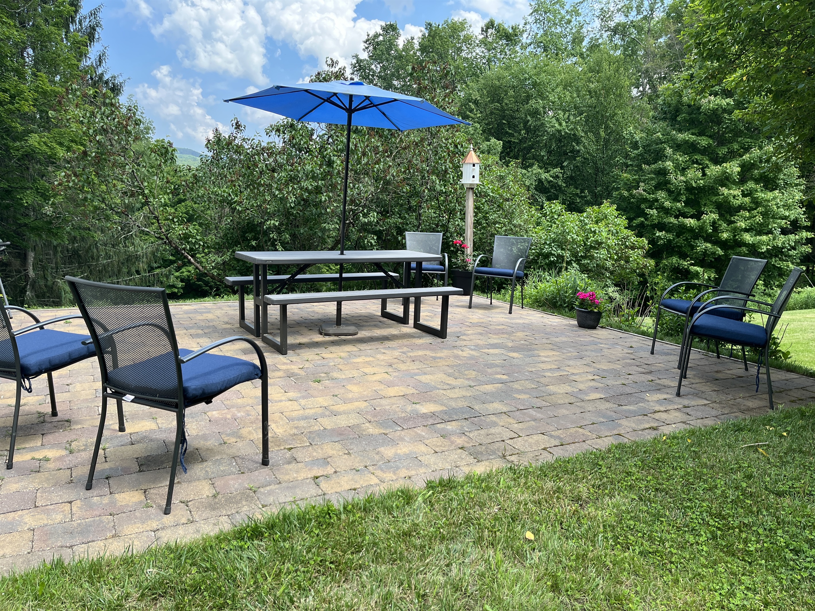 Side patio with chairs, table and charcoal grill