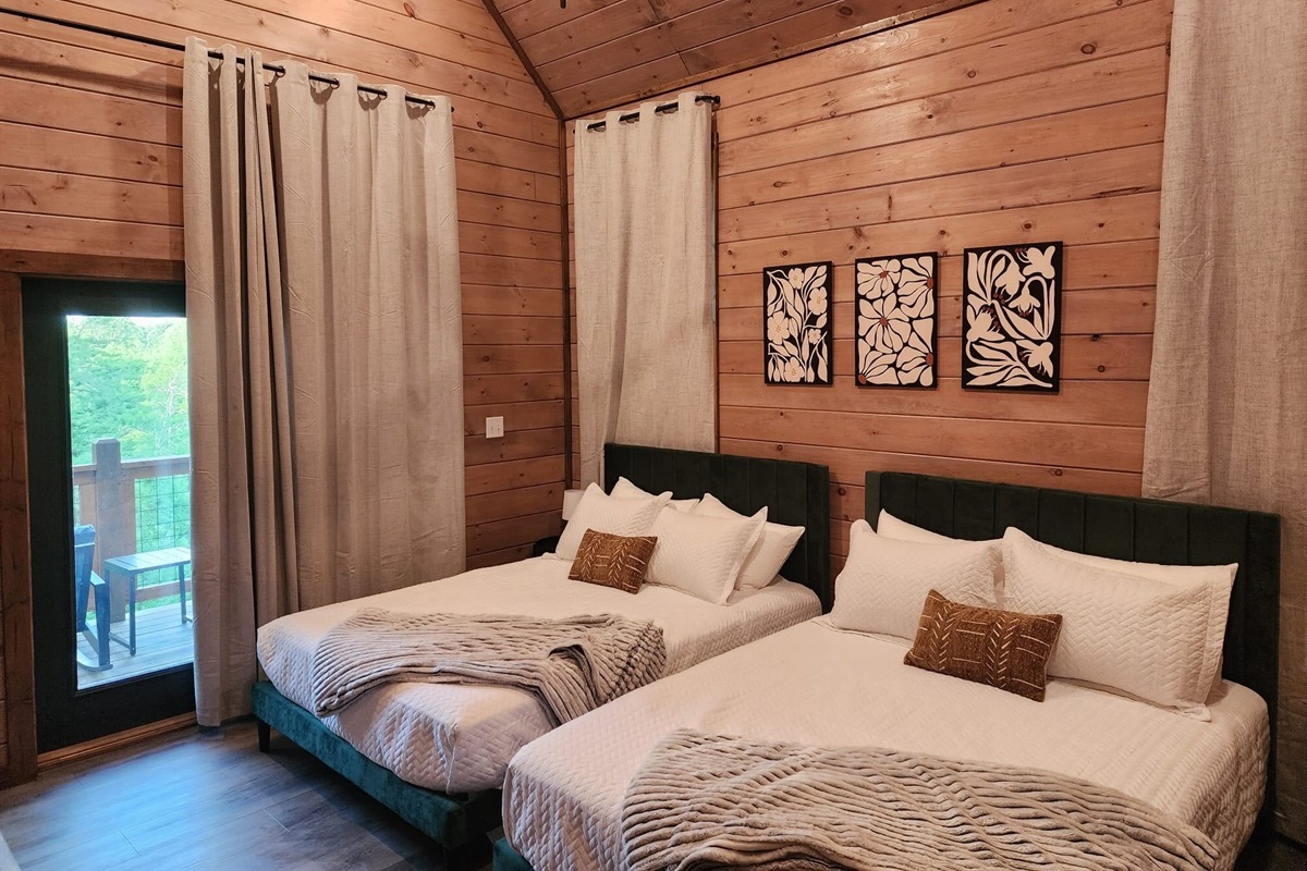 Bedroom with two queen beds, modern art, and plush linens
