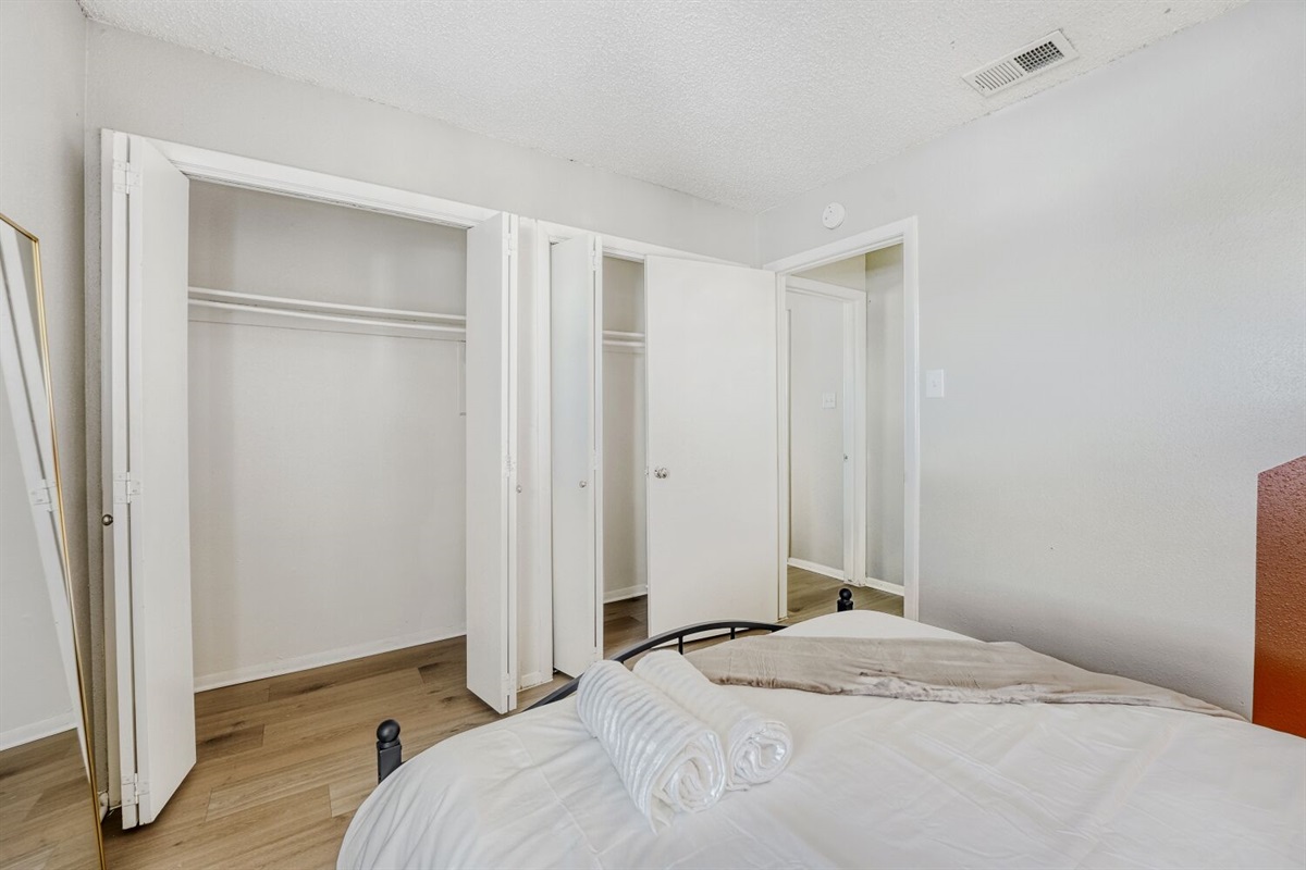 Bright bedroom with ample closet space and a clean, minimalist design.