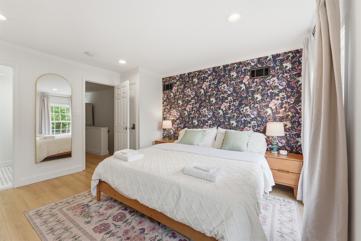 Stylish king suite with dramatic designer wallpaper, cozy bedside lighting, and thoughtfully curated furnishings