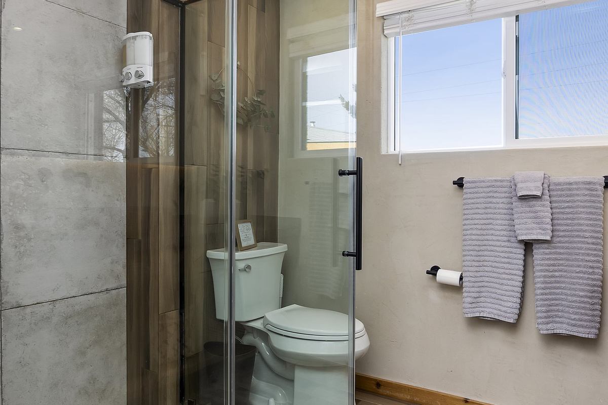 Unit 2 bath — glass and stone walk-in shower, updated and spotless