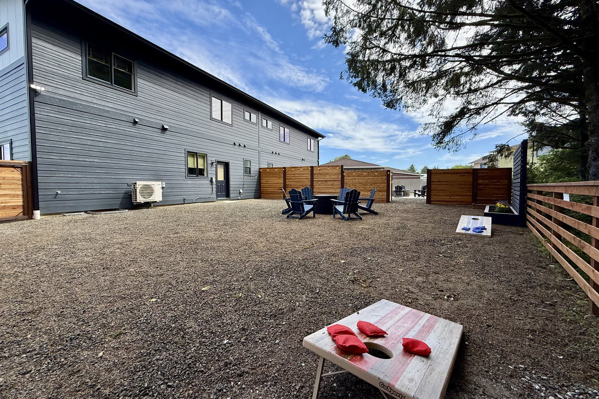 Start a cornhole tournament in the side yard — the boards are already set up and there is room to spare for the next round of players.