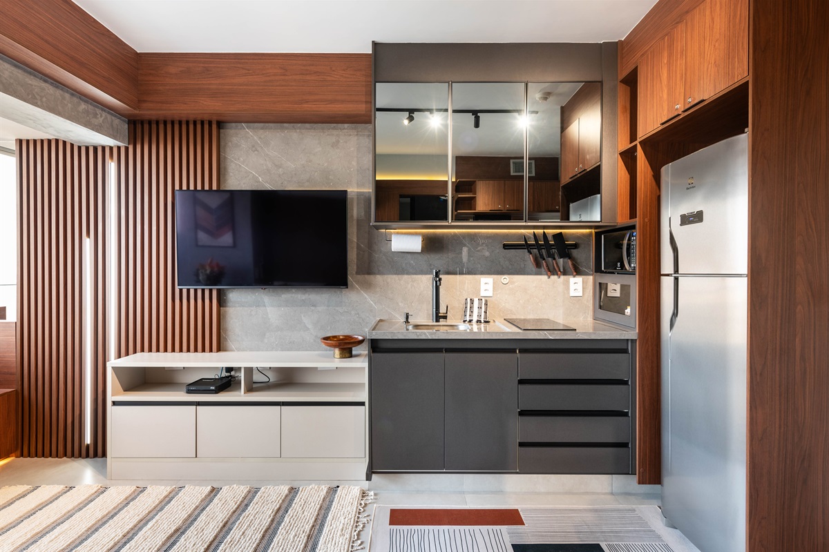 🍳 Cozinha completa integrada à sala, com geladeira, micro-ondas, cooktop e armários planejados. Praticidade total para estadias curtas ou longas