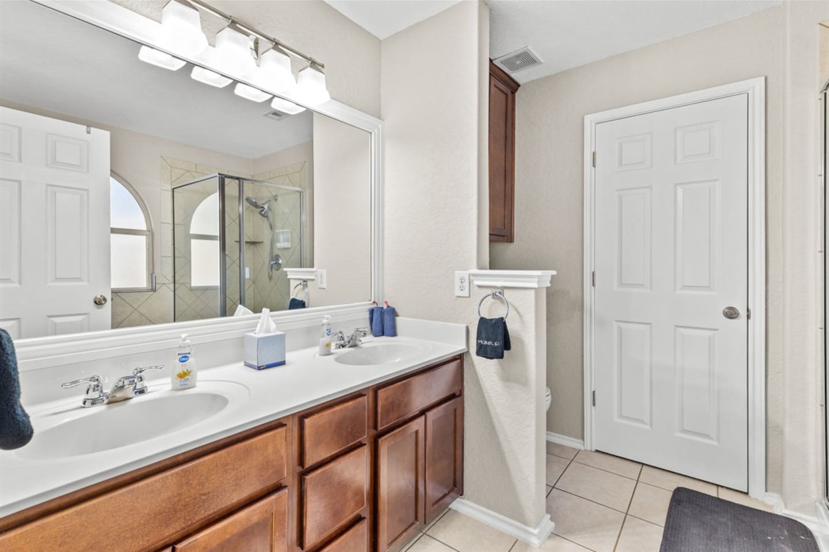 Spacious master bathroom with double vanity, ample counter space, and premium Ginger Lily Farms toiletries for a comfortable stay.
