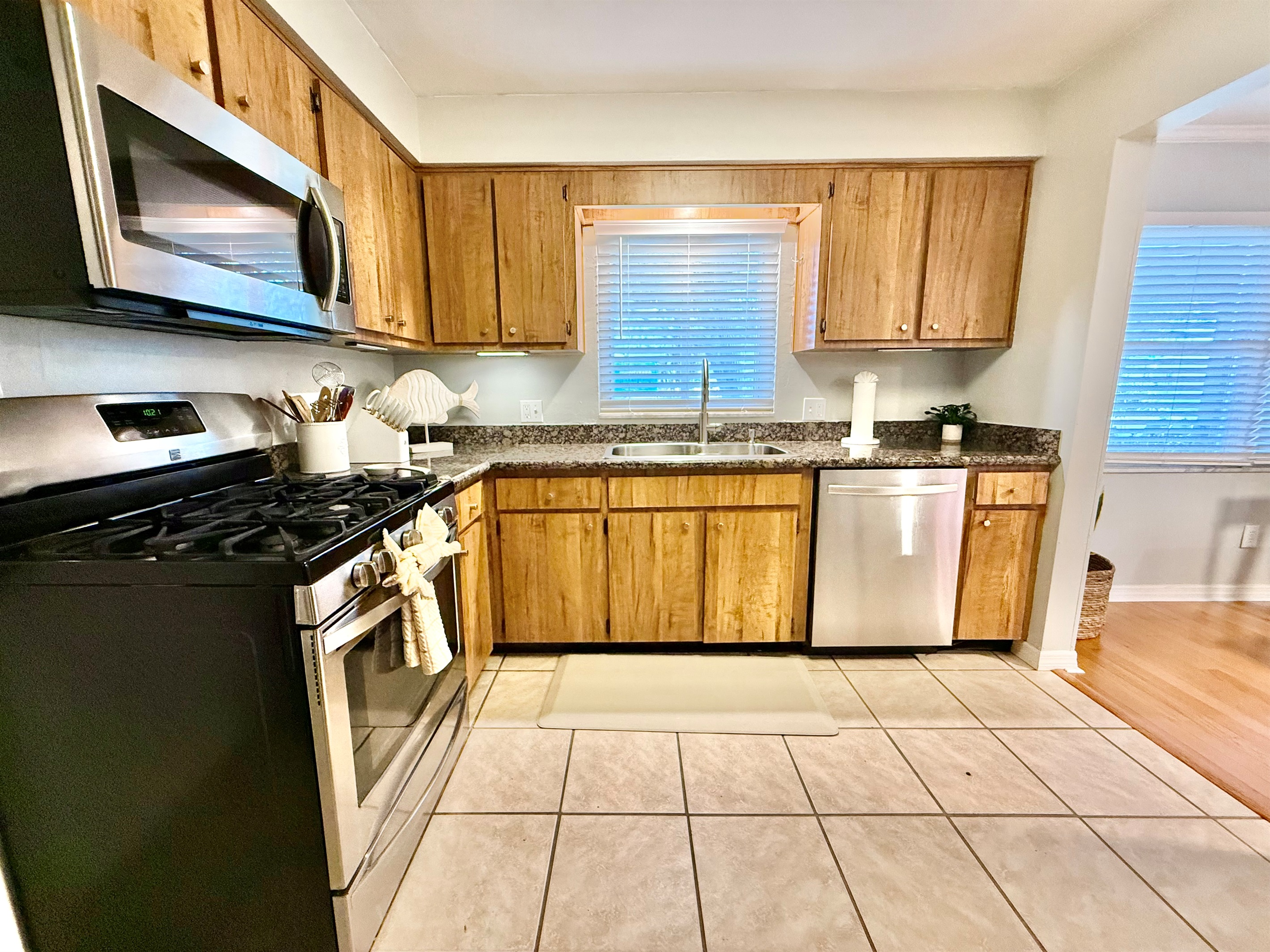 Granite countertops, gas stove, and dishwasher make cooking and cleanup a breeze in this practical space.