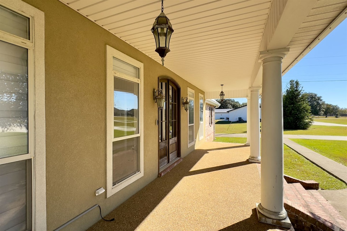 The porch opens to a well-kept lawn and a quiet residential street, perfect for guests seeking comfort and community.

