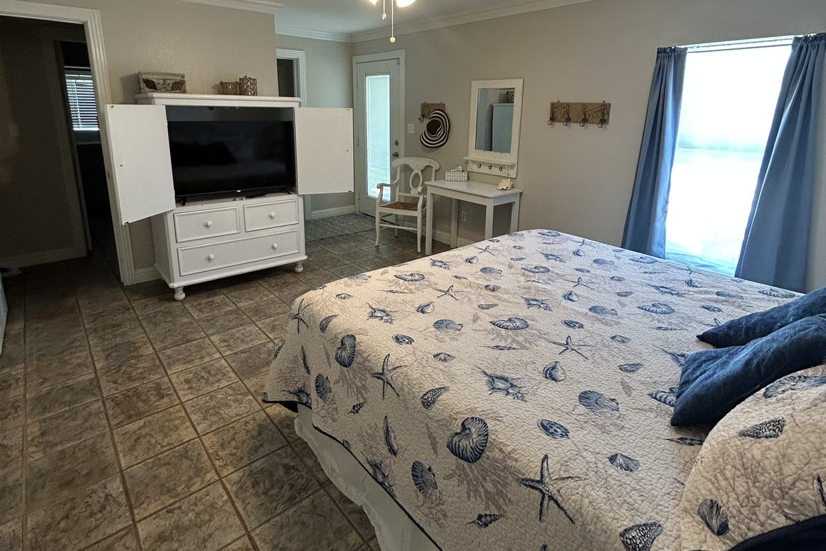 King Suite with ensuite bathroom and direct pool/backyard access (Ground-level). Includes an optional twin rollaway bed for an additional family member, with plenty of space to place it comfortably at the foot of the king bed without crowding the room.