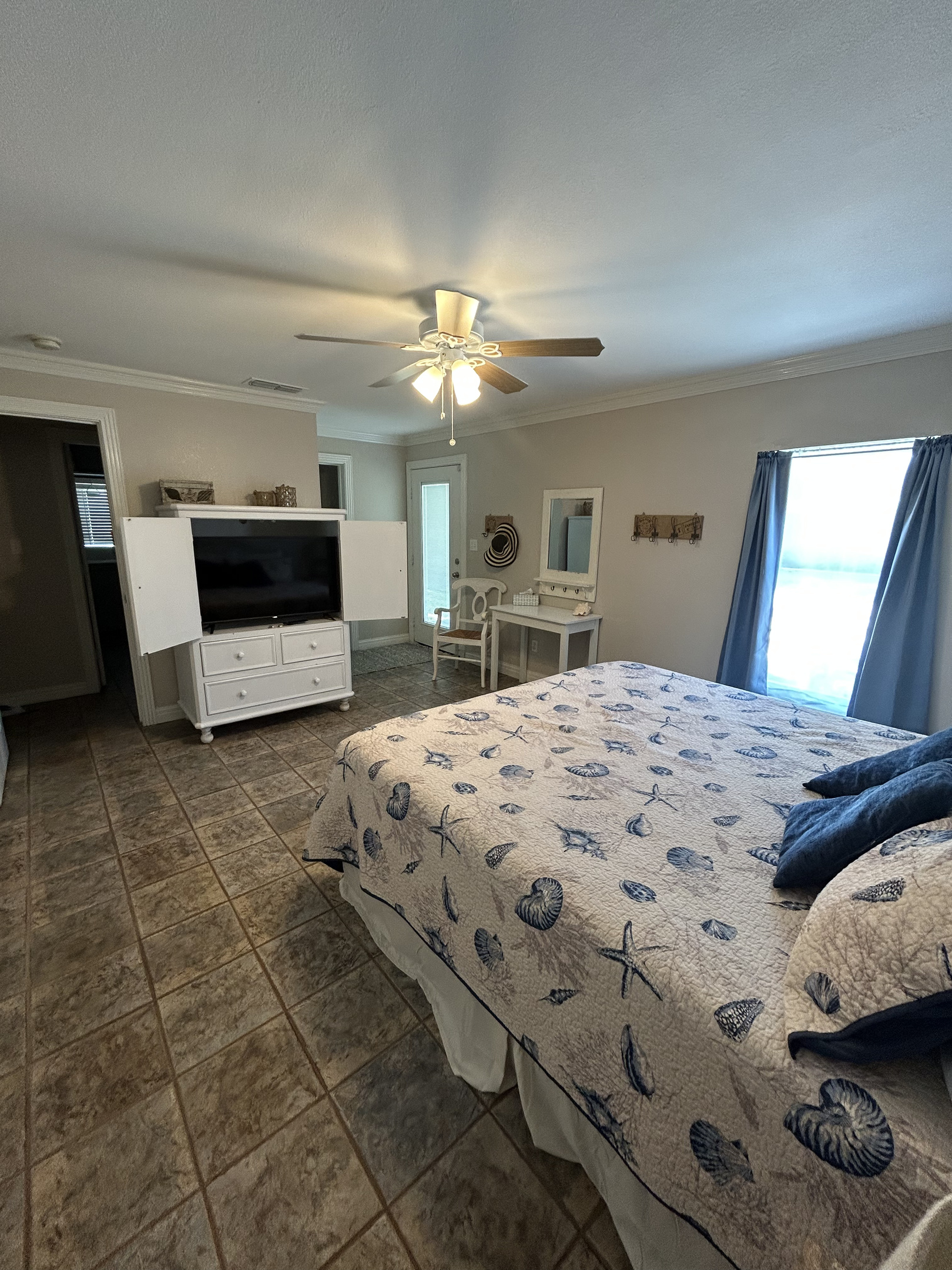 King Suite with ensuite bathroom and direct pool/backyard access (Ground-level). Includes an optional twin rollaway bed for an additional family member, with plenty of space to place it comfortably at the foot of the king bed without crowding the room.