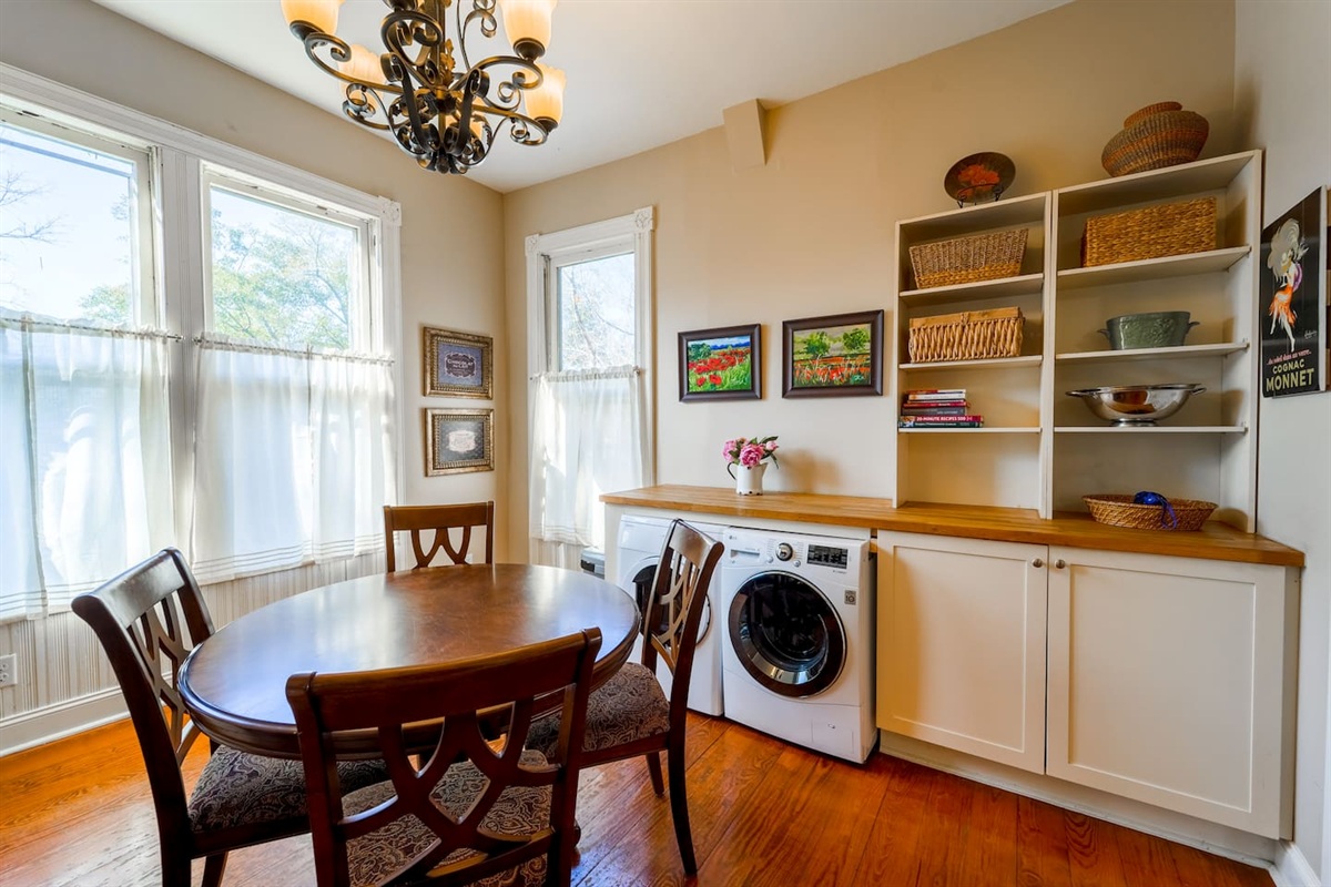 Easy access to front-loading washer and dryer with everything you need. Attached is a built-in shelving unit with cookbooks and warm decor. 