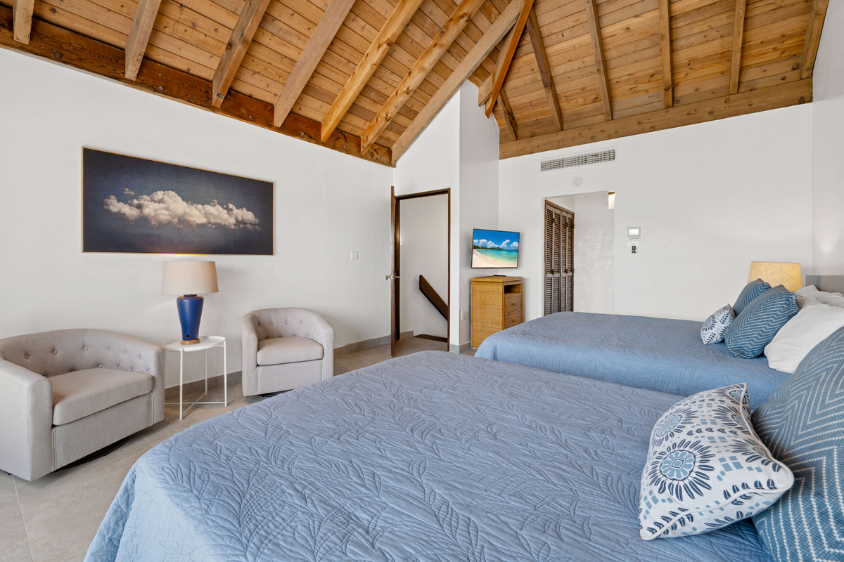 Spacious primary suite featuring comfortable beds and a relaxing island atmosphere.