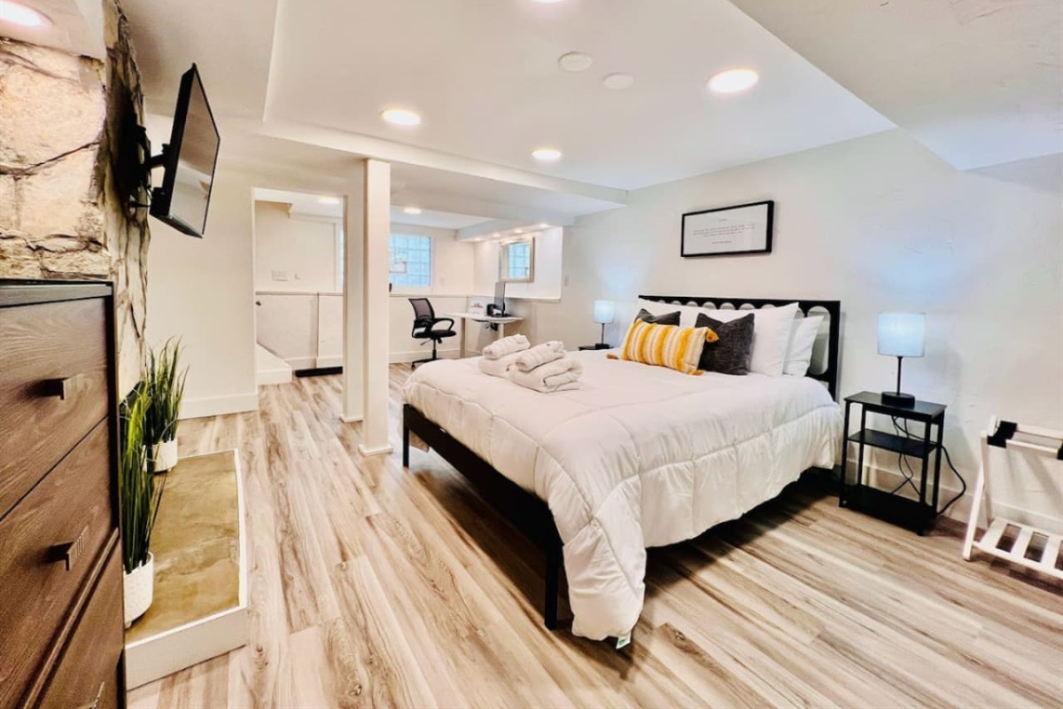 Spacious queen-sized bedroom with a dedicated working space and a TV, offering the perfect blend of comfort, productivity, and entertainment.