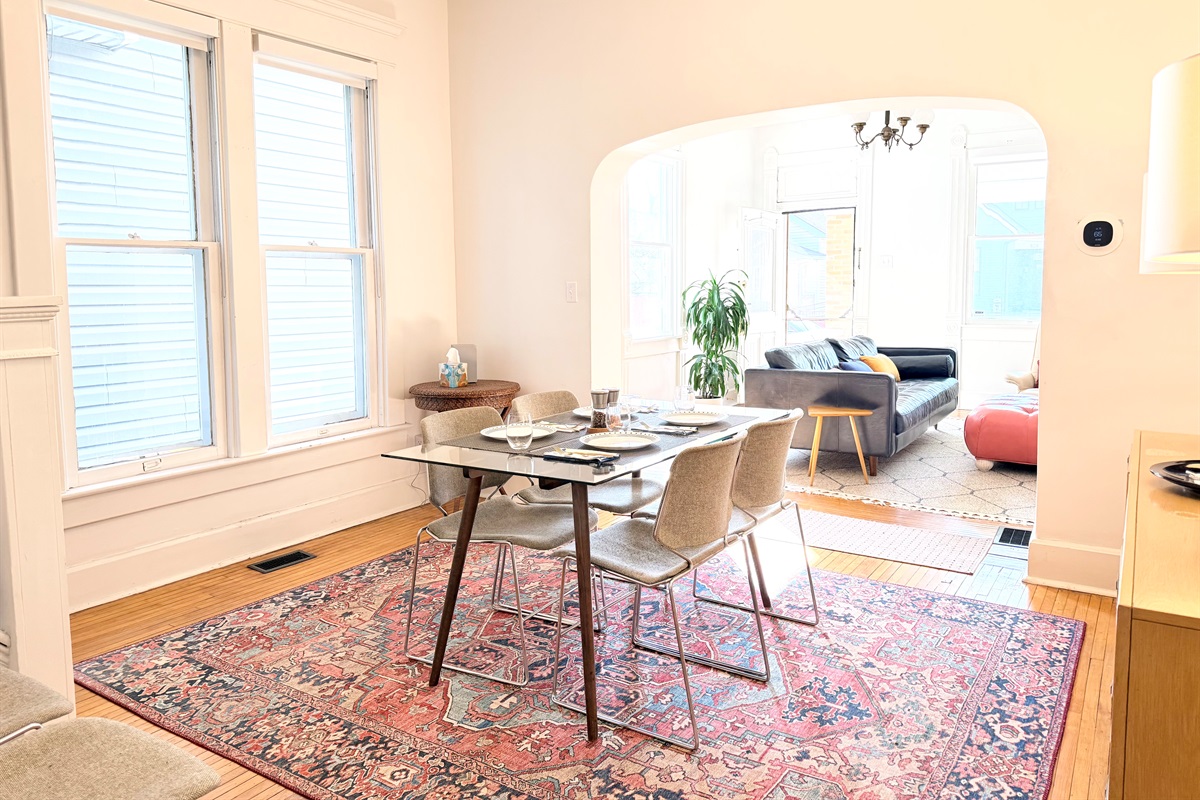 Natural light pours through tall windows, while classic arches create a beautiful sense of flow between the dining 