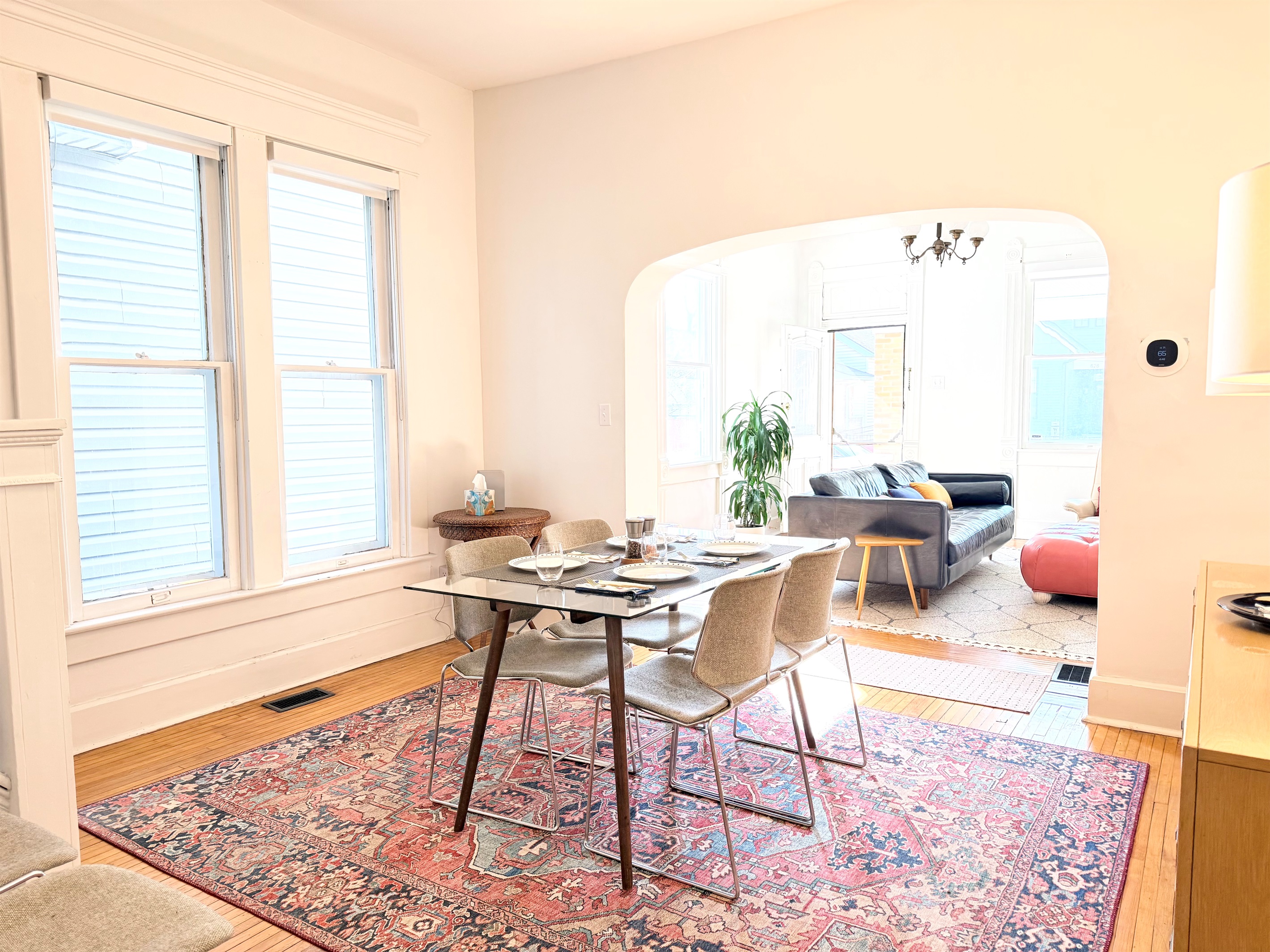 Natural light pours through tall windows, while classic arches create a beautiful sense of flow between the dining 