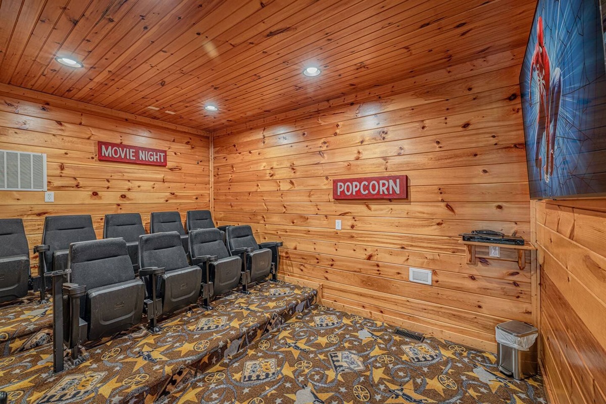 rivate theater room with tiered recliner seating and wall-mounted screen. Gatlinburg cabin with movie theater &mdash; ideal for groups of 12.