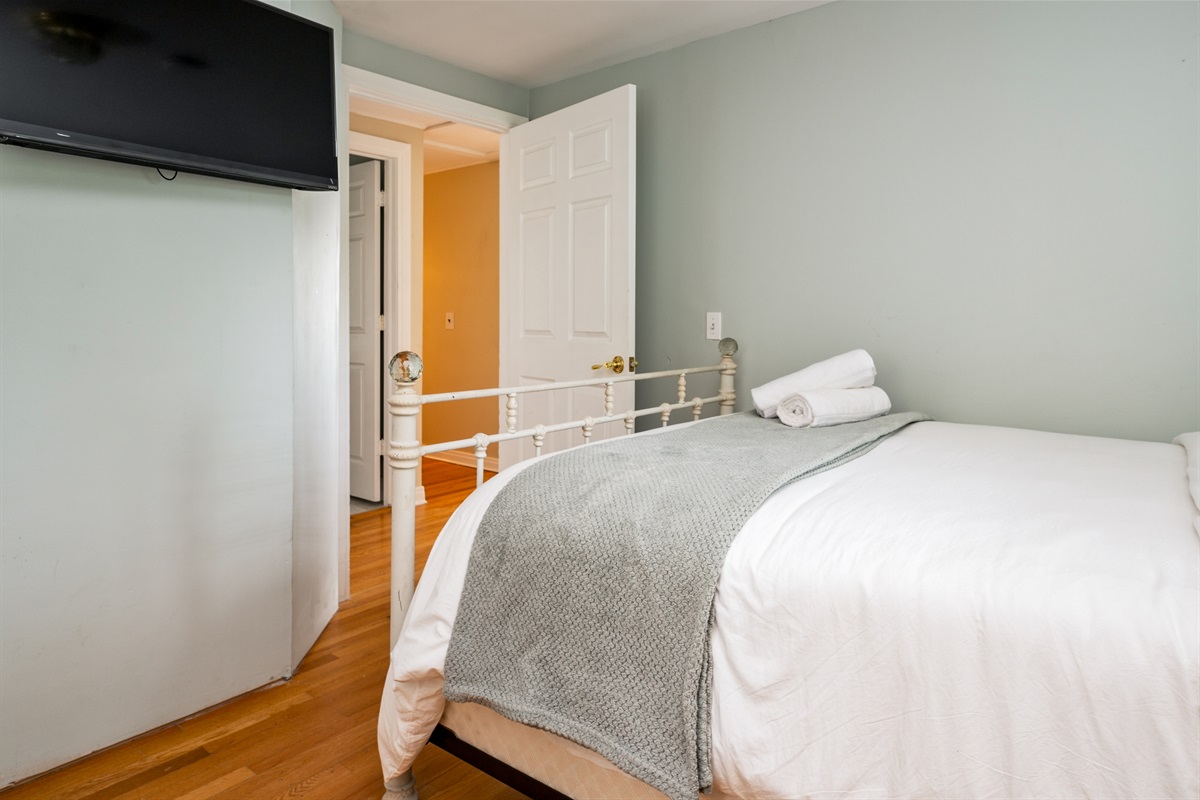 Unwind in comfort with fresh linens, hardwood floors, and a wall-mounted TV for cozy nights in 📺🛌✨