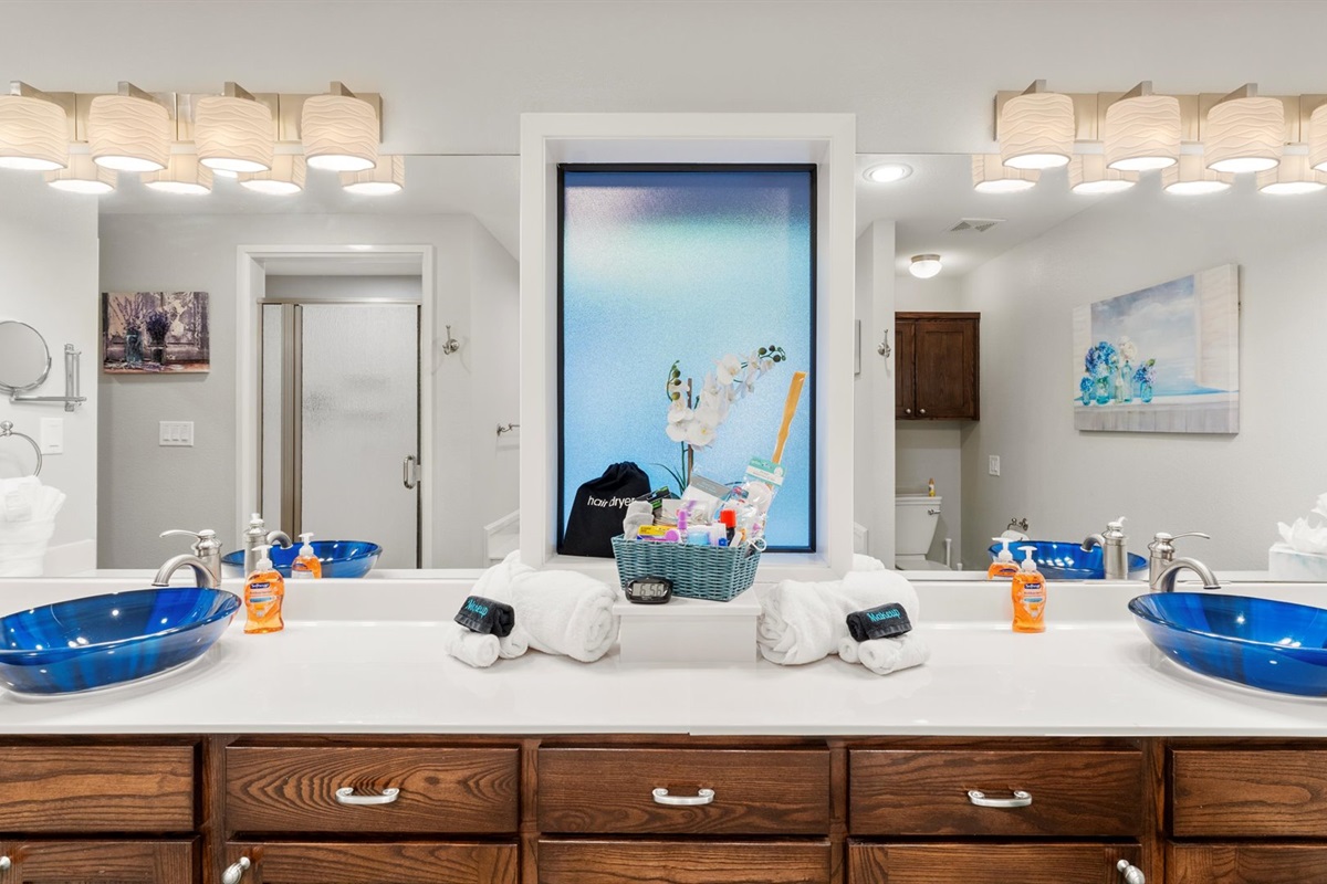 King 1 Bathroom has custom sinks, great lighting, a makeup mirror, and a "forgot something" basket with essentials like a hair dryer, razors, and more. Fresh towels and Kleenex are provided.