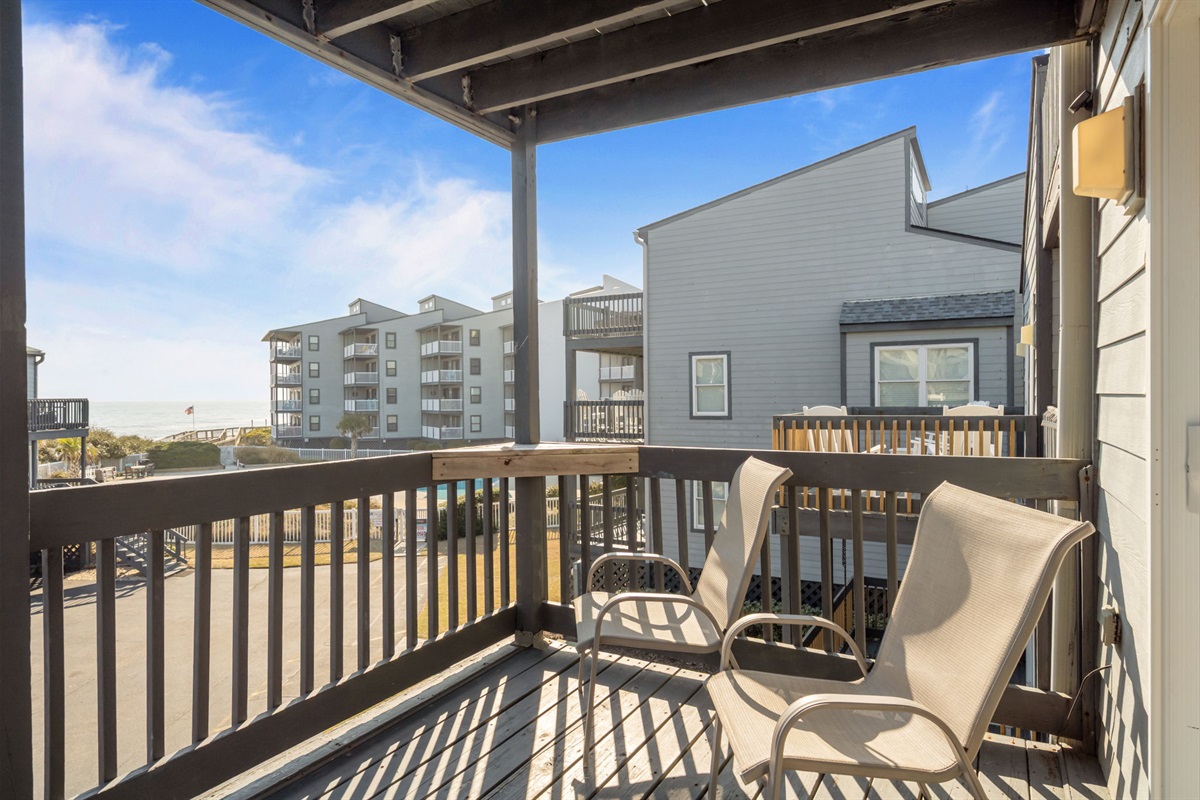 Spacious deck area with outdoor chairs perfect for unwinding after a day on the beach