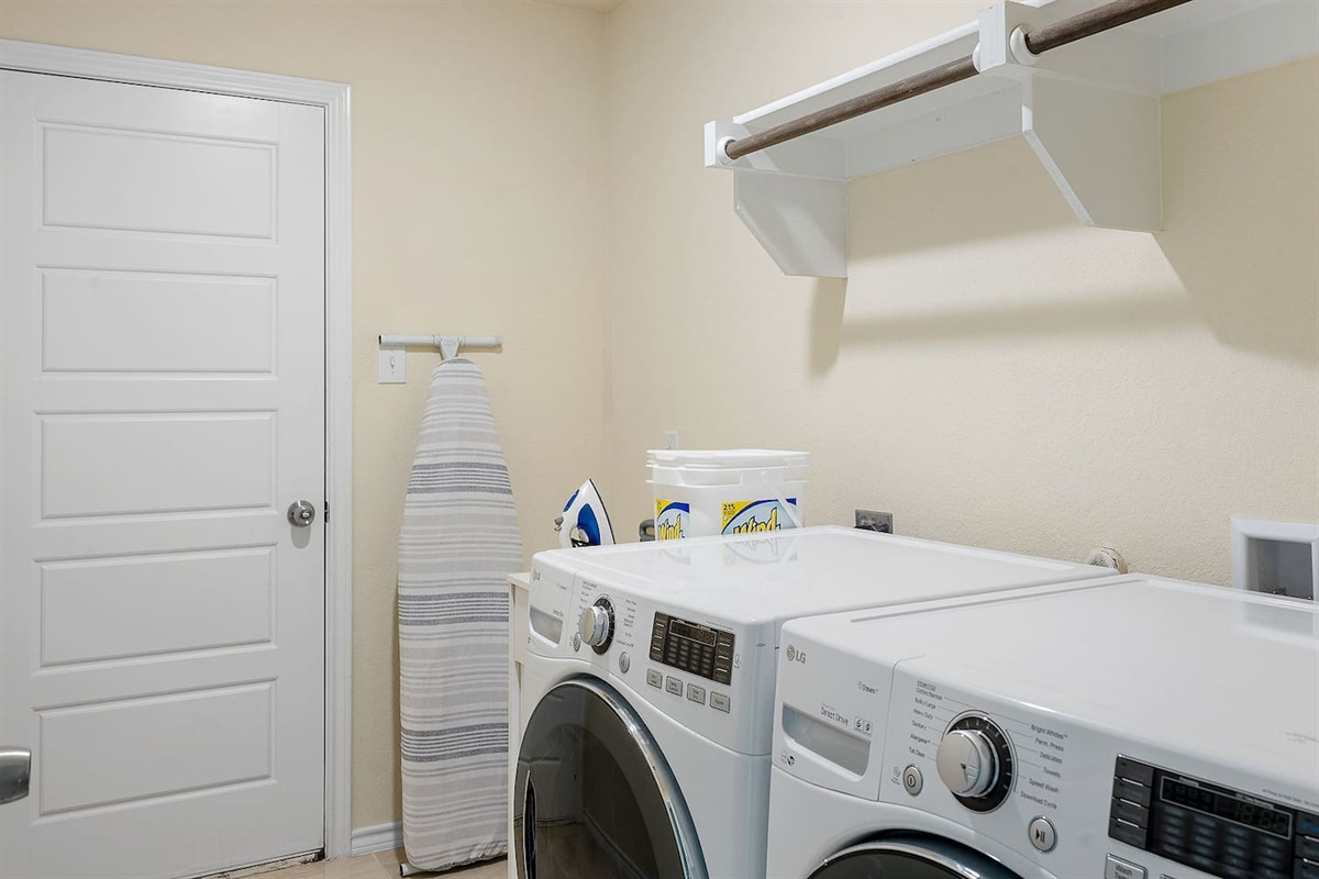 Enter a functional laundry room equipped with modern washer and dryer units for your convenience.