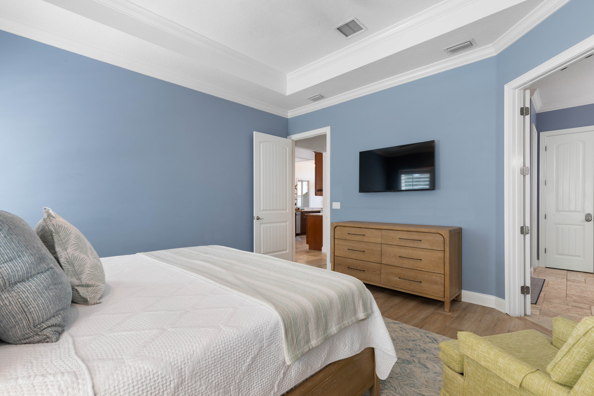 Close the door and the Primary Suite becomes a quiet retreat from the main living area, with a TV and armchair.
