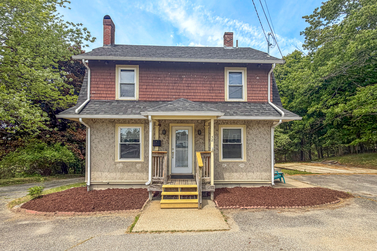 Historic stone-pressed stucco siding defines the exterior of this private two-story Downeast vacation home. This architectural asset establishes the property identity, while the surrounding paved parking area provides effortless regional transit access.