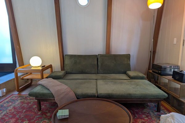 Relax in style. This green corduroy sofa easily expands into a cozy lounger during the day, and an extra sofa bed at night. Additional bedding is stored in the upstairs closet.