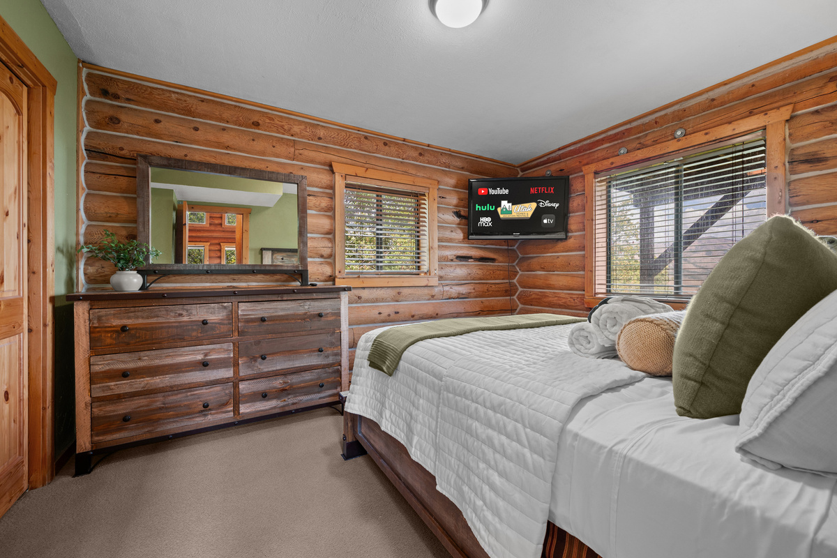Main-level queen bedroom with natural wood accents and comfortable furnishings.
