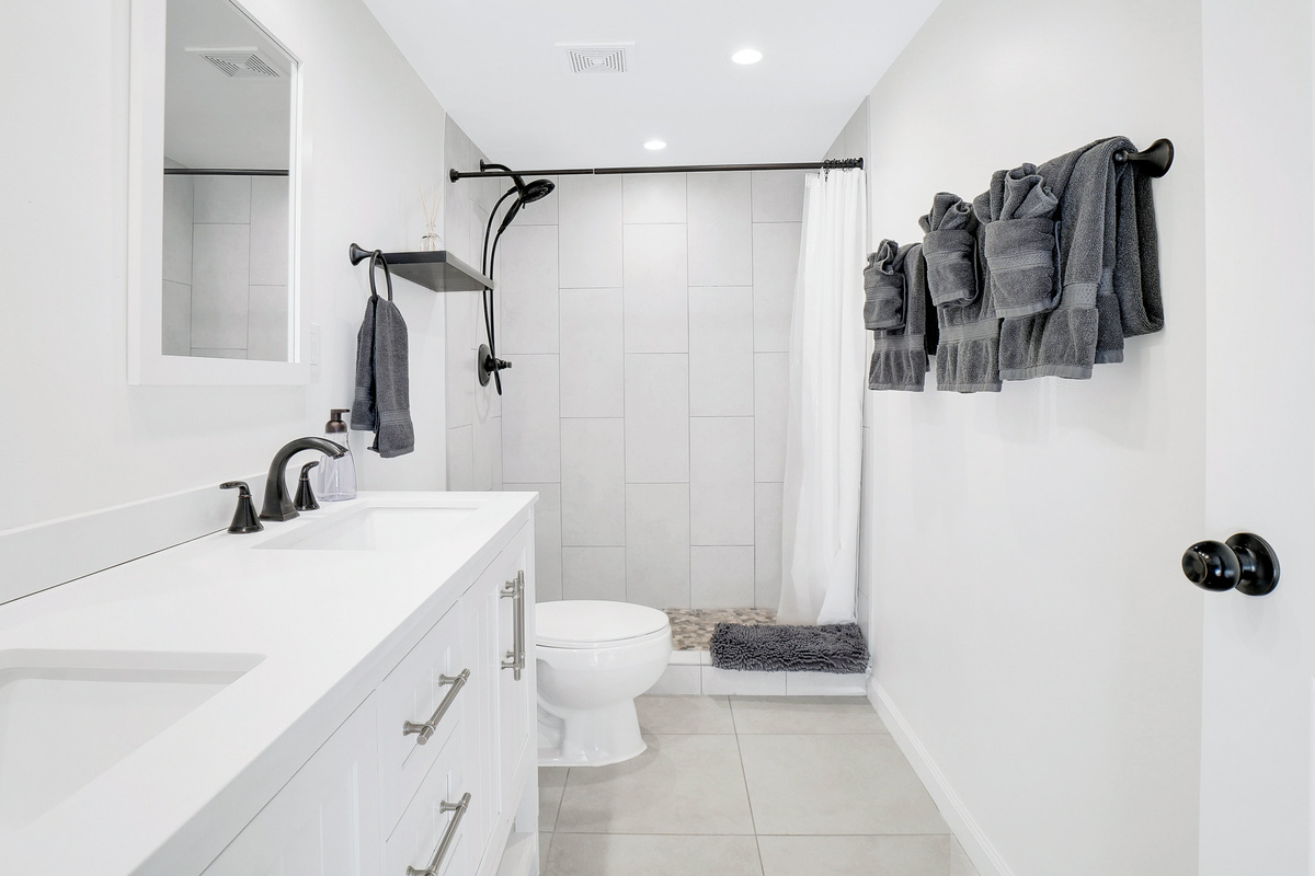 Primary bathroom with dual sinks and walk-in tile shower