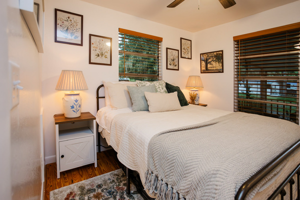A quiet queen bedroom with garden views on both sides, plus closet storage - cozy linens and warm lamplight.