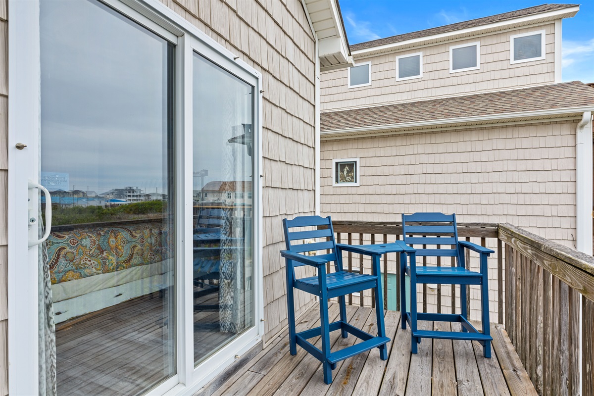 Cozy side balcony with bistro-style seating for a quiet escape