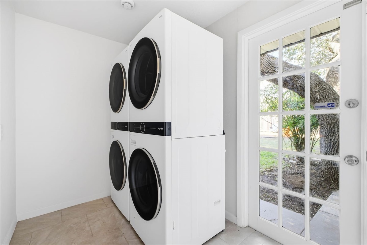 Two stackable washer and dryer units located off the kitchen