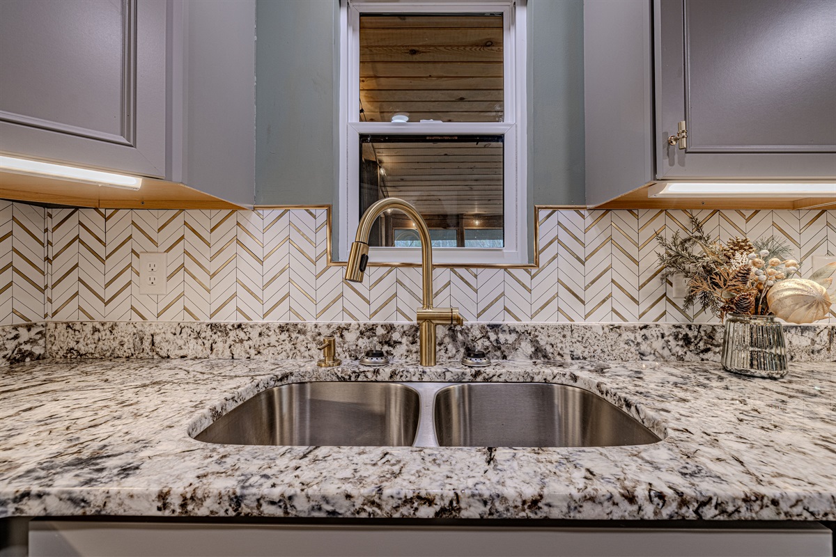 The kitchen&rsquo;s sophisticated gold chevron backsplash adds a touch of mid-century glamour to your gourmet cooking experience.
