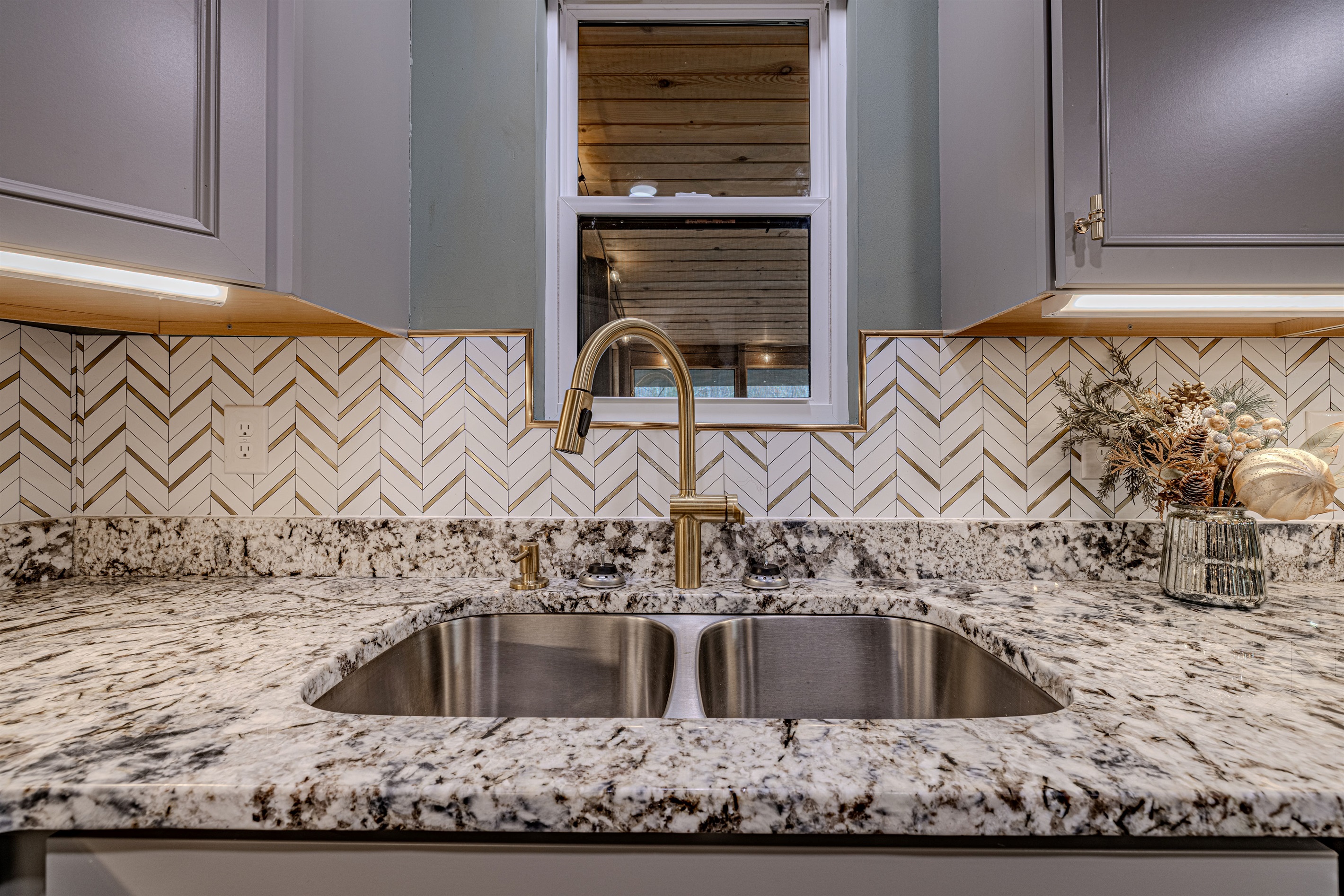 The kitchen’s sophisticated gold chevron backsplash adds a touch of mid-century glamour to your gourmet cooking experience.
