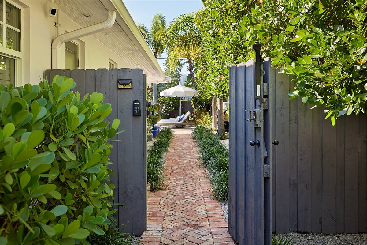 Enter the property through a secure digital gate and follow the charming Chicago brick pathway leading to the pool.