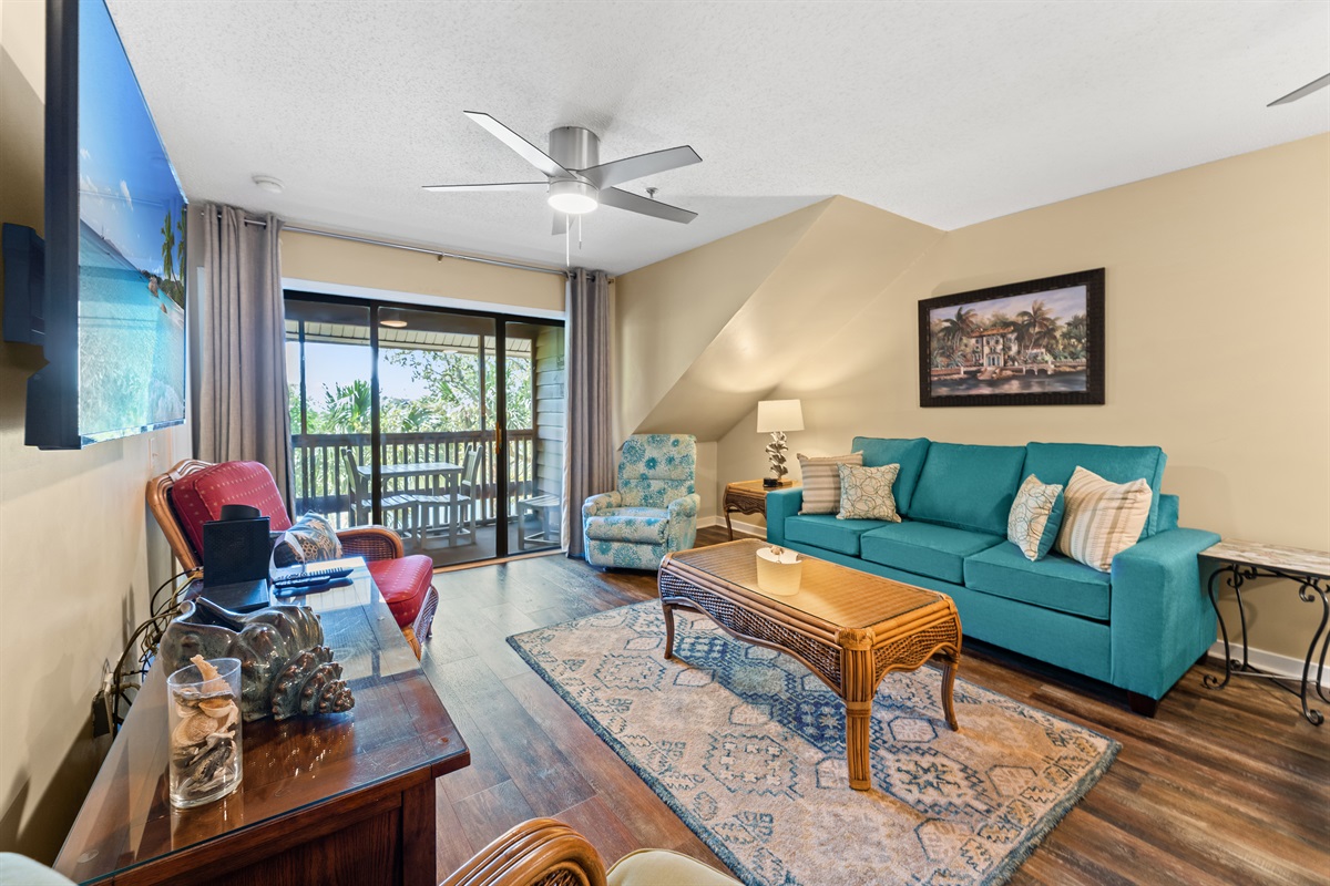 Open concept- large living area with sleeper sofa, large TV and patio access