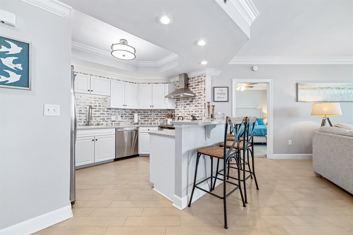This fully functional kitchen boasts stainless steel appliances, sleek countertops, a decorative backsplash, and ample cabinet storage, ideal for everyday cooking and entertaining.