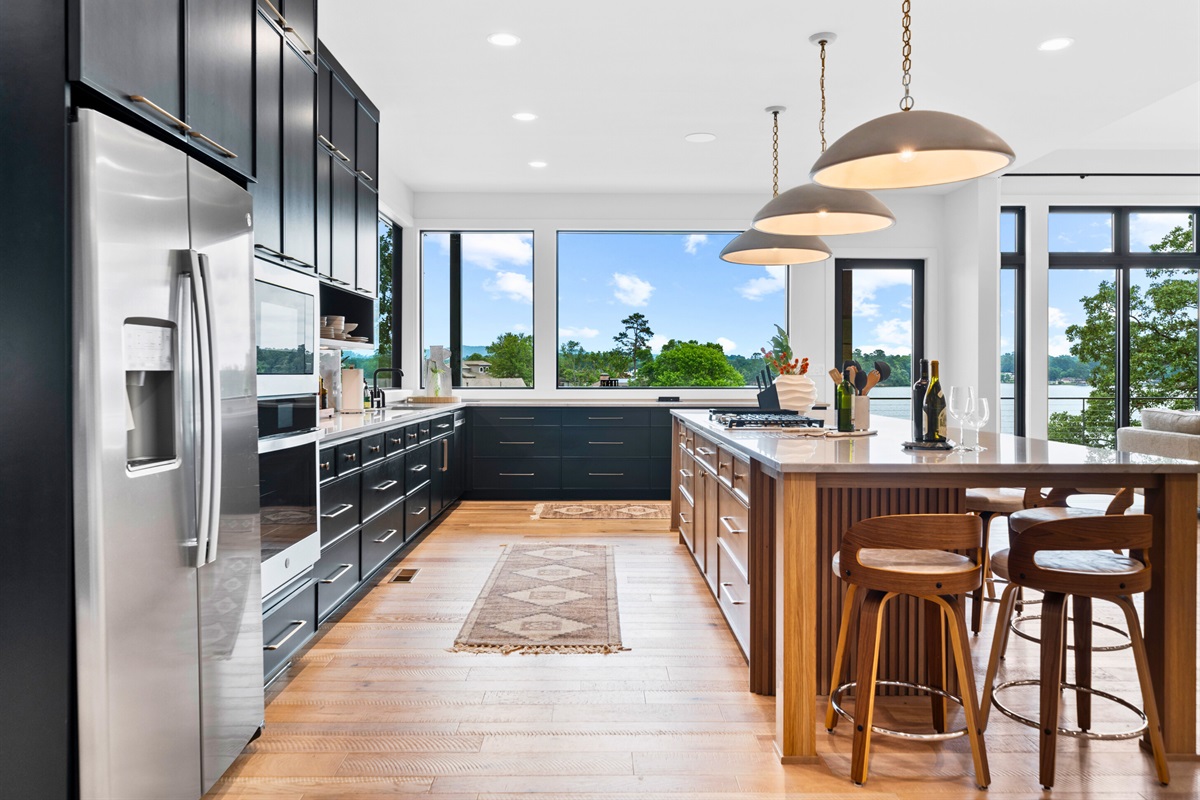 Cooking is a joy in this spacious kitchen, complete with sleek black cabinets and vibrant art. The open layout is perfect for entertaining.